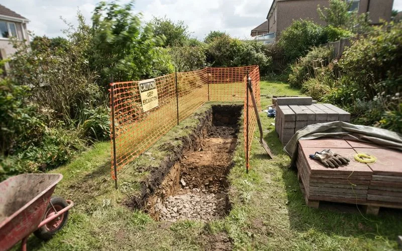 Excavated driveway trench properly fenced off with warning barriers around the perimeter